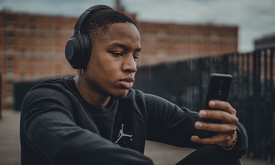 Persona con auriculares escuchando contenido de audio desde un dispositivo móvil