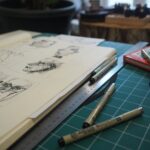Persona trabajando con dibujos sobre una mesa; imagen ilustrativa de un proceso creativo audiovisual